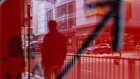 A pedestrian reflected in a sign in Hong Kong, China.