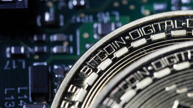 Two coins representing Bitcoin cryptocurrency sit on a computer circuit board in this arranged photograph in London, U.K. 