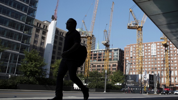A pedestrian walks past cranes at a construction site in Montreal, Quebec, Canada, on Monday, Aug. 20, 2018. Median single-family home prices in Montreal rose 5.7% to C$336,250 in July from a year ago, according to the Greater Montreal Real Estate Board (GMREB). 