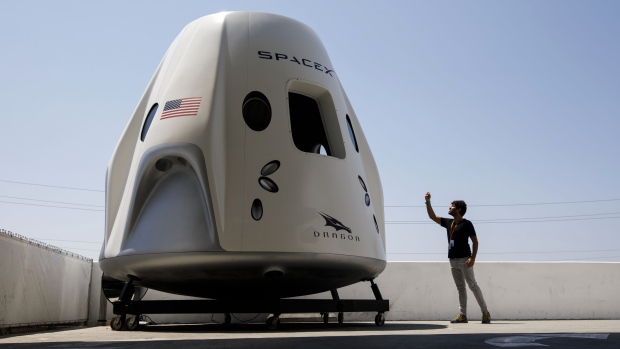 A person takes pictures of a mock up of the Crew Dragon spacecraft at SpaceX headquarters in Hawthorne, California. 