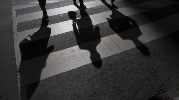 The shadow of pedestrians are seen on the ground of a crosswalk in Toronto, Ontario, Canada. 