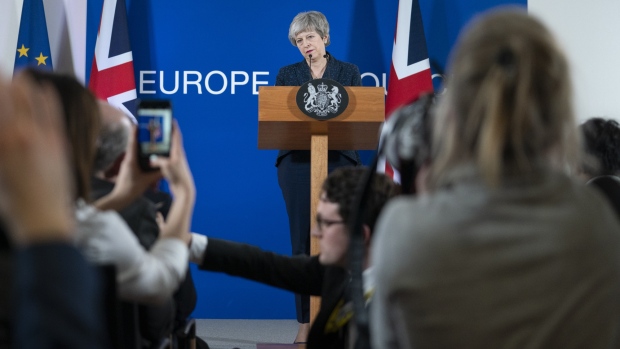 Theresa May, U.K. prime minister, listens during a news conference at a European Union (EU) leaders summit in Brussels, Belgium, on Friday, March 22, 2019. European Union leaders staved off the threat of the U.K. crashing out of the bloc without a deal next Friday by giving Theresa May an extra two weeks to work out what to do if she fails to get her agreement past the British Parliament by the end of the month. 