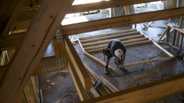 A worker saws a section of lumber inside a home under construction in Ellenton, Florida, U.S., on Thursday, July 6, 2017. 