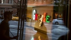 Pedestrians are reflected in a window looking into a lobby of the Google Inc. offices in New York. 