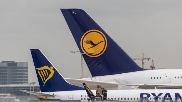 Passenger aircraft, operated by Ryanair Holdings Plc, left, and Deutsche Lufthansa AG, sit on tarmac beyond the construction site of Frankfurt airport's new Terminal 3 in Frankfurt, Germany, on Monday, April 29, 2019. 