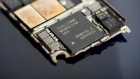 A Qualcomm Inc. baseband modem integrated circuit (IC) chip, center, of an Apple Inc. iPhone 6 smartphone is seen in an arranged photograph in Bangkok, Thailand, on Saturday, Feb. 3, 2018. Apple Chief Executive Officer Tim Cook told shareholders on Feb. 13 at the company's annual meeting to expect higher dividends and stressed that succession planning is a priority. 