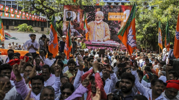 India election 2019: Supporters celebrate in front of a banner featuring Narendra Modi