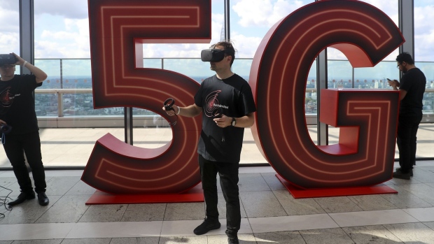 A man uses a virtual-reality headset in front of a 5G logo during the launch of Vodafone Group Plc's 5G wireless network in London, U.K., on Wednesday, July 3, 2019. Vodafone switched on the U.K.'s second 5G wireless network on Wednesday, kicking off a commercial battle with dominant rival EE that could shape a decade of sales. 