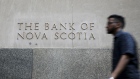 A pedestrian passes in front of a building displaying The Bank of Nova Scotia (Scotiabank) signage in the financial district of Toronto, Ontario, Canada, on Thursday, July 25, 2019. Canadian stocks fell as tech heavyweight Shopify Inc. weighed on the benchmark and investors continued to flee pot companies. 