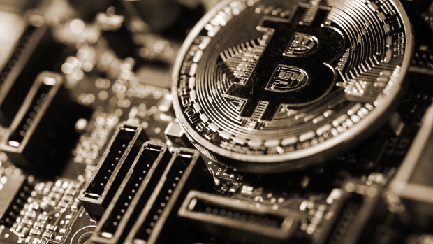 A coin representing Bitcoin cryptocurrency sits on a computer circuit board in this arranged photograph in London, U.K., on Tuesday, Feb. 6, 2018. Cryptocurrencies tracked by Coinmarketcap.com have lost more than $500 billion of market value since early January as governments clamped down, credit-card issuers halted purchases and investors grew increasingly concerned that last years meteoric rise in digital assets was unjustified. 