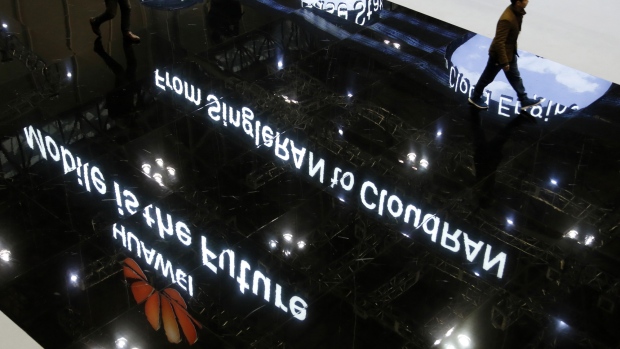 The Huawei Technologies Co. logo is reflected on the floor as a visitor walks through the venue at the annual Huawei Global Mobile Broadband (MBB) Forum in Chiba, Japan, on Thursday, Nov. 24, 2016. The forum runs through to Nov. 25. 