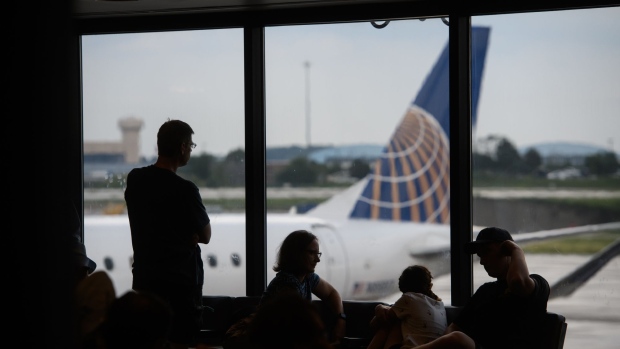 People watch as a United Airlines Holdings Inc. plane arrives at a gate at the Pittsburgh International Airport (PIT) in Moon Township, Pennsylvania, U.S., on Tuesday, July 2, 2019. Programs adopted or being considered by a number of airports allow people beyond security checkpoints so they can meet arriving relatives or just hang out as airports expand options to fill passenger dwell time. 