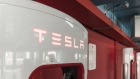 Electric vehicle charging stations stand in a Tesla Inc. Supercharger station at a parking garage in