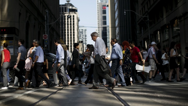 Pedestrians cross a street in the financial district of Toronto, Ontario, Canada, on Thursday, July 25, 2019. Canadian stocks fell as tech heavyweight Shopify Inc. weighed on the benchmark and investors continued to flee pot companies. 