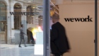 The WeWork logo sits on the exterior of a glass door at the co-working office space, operated by the parent company We Co., on Eastcheap in London, U.K., on Monday, Oct. 7, 2019. While WeWork has been rapidly expanding in Canada, the New York-based company is facing challenges on multiple fronts with Landlords in London and New York the most exposed to any further deterioration at the co-working firm. 