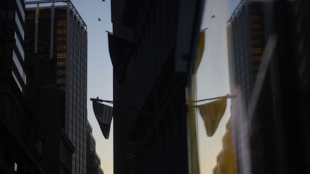 An American flag is reflected in the window of a building near the New York Stock Exchange (NYSE) in New York, U.S., on Thursday, Dec. 27, 2018. Volatility returned to U.S. markets, with stocks tumbling back toward a bear market after the biggest rally in nearly a decade evaporates. 