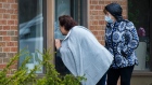 Two sisters visit their mother through the window at a seniors retirement residence in Mississauga
