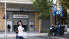 <p>Greek national flags outside an Alpha Bank AE branch in Athens.</p>