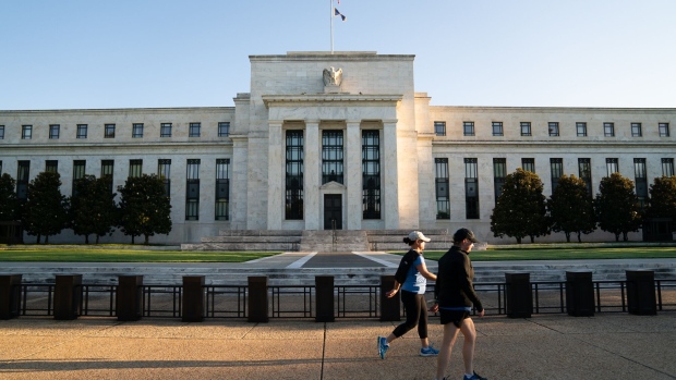 <p>Joggers pass the Marriner S. Eccles Federal Reserve building in Washington, DC.</p>