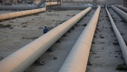 An employee walks along transport pipes leading to oil storage tanks at the Juaymah tank farm at Saudi Aramco's Ras Tanura oil refinery and oil terminal in Ras Tanura, Saudi Arabia, on Monday, Oct. 1, 2018. Saudi Aramco aims to become a global refiner and chemical maker, seeking to profit from parts of the oil industry where demand is growing the fastest while also underpinning the kingdom’s economic diversification. Photographer: Simon Dawson/Bloomberg