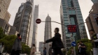 Pedestrians cross a road in Pudong's Lujiazui Financial District in Shanghai, China, on Monday, April 15, 2024. China's economic growth beat expectations in the first quarter as the industrial sector powered forward, although a tail-off in March activity signaled more support may be needed to sustain that momentum. Photographer: Raul Ariano/Bloomberg