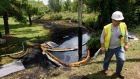 Oil from a ruptured Enbridge pipeline is vacuumed out of water near Kalamazoo River