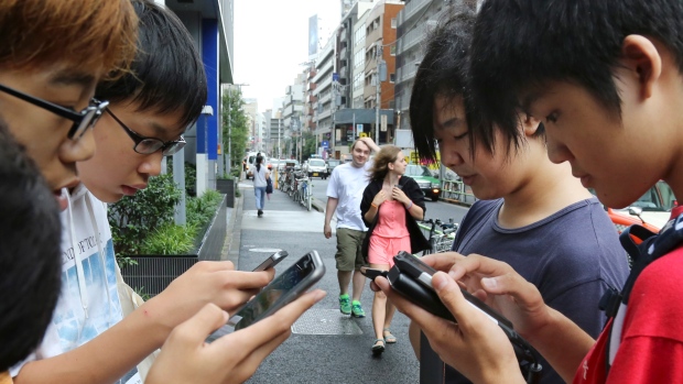 Japanese students play "Pokemon Go" in Tokyo