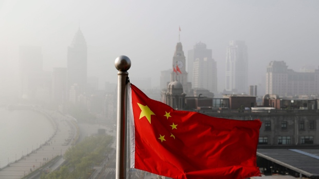 A Chinese national flag flutters against the office buildings at the Shanghai Bund