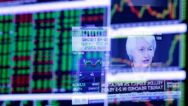 Janet Yellen is reflected in a specialist's screen on the floor of the New York Stock Exchange