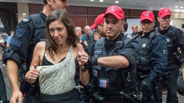 A demonstrator is taken away by police after disrupting the NEB public hearing, Aug. 29, 2016