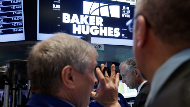 Traders gather at the post that handles Baker Hughes on the floor of the New York Stock Exchange.