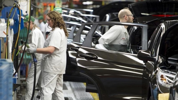 Production Associates inspect cars moving along assembly line at Honda manufacturing plant 