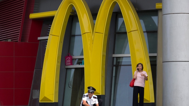 A security guard rests near a giant logo for McDonald in northern China's Tianjin Municipality