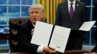 U.S. President Donald Trump holds up the executive order on withdrawal from TPP