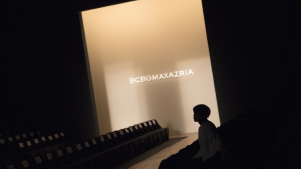 A worker sits next to the runway before the BCBG Max Azria Fall 2015 collection show in 2015. 