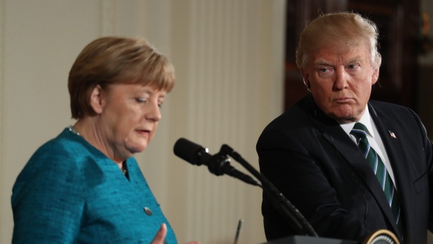 President Donald Trump looks to German Chancellor Angela Merkel during a joint news conference