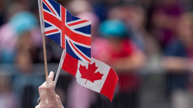 A spectator holds up Canadian and Union Jack flags during Queen Elizabeth's 2010 visit to Ottawa