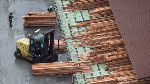 Workers sort and move lumber at the Delta Cedar Sawmill in Delta, B.C.