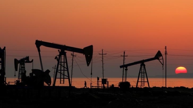 Pump jacks are silhouetted against the rising sun on an oilfield in Baku, Azerbaijan