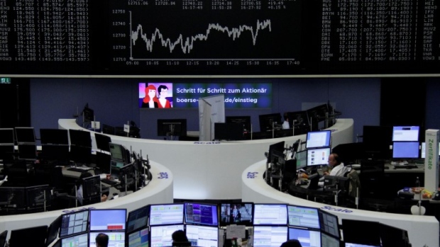 Traders work in front of the German share price index, DAX board, at the stock exchange in Frankfurt