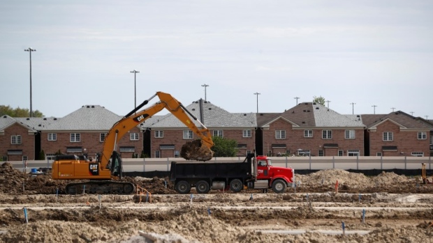 Construction workers build homes on a lot in Vaughan, Ontario