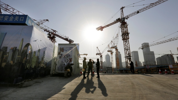 Workers chat outside a construction site in Beijing's central business district, December 29, 2014. 