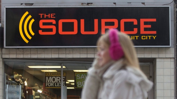 A woman talks on her cell phone as she walks past a The Source store in Ottawa.
