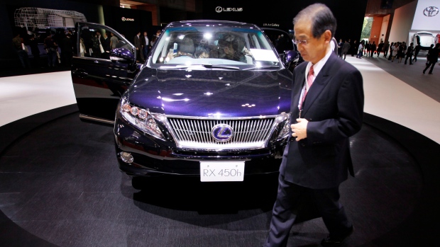 A visitor walks about Toyota Motor Corps.'s hybrid Lexus RX450h on display at the Tokyo Motor Show