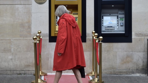 A woman walks past a golden ATM, marking the location of the first 'hole in the wall'