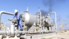 A worker checks the valve of an oil pipe at Nahr Bin Umar oil field, north of Basra, Iraq December 2