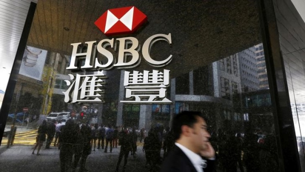 A man walks past a logo of HSBC outside a branch at the financial Central district in Hong Kong