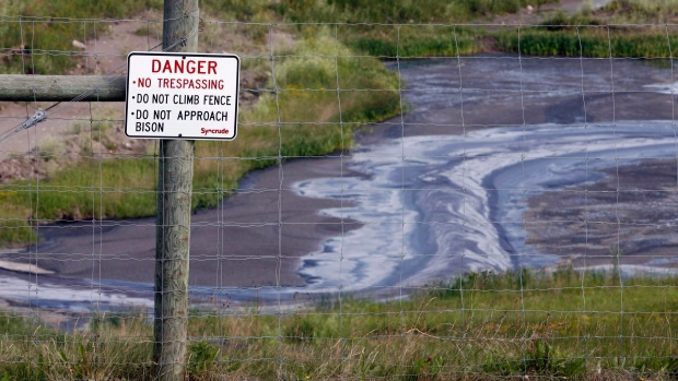 Tailings drain into a pond at the Syncrude oil sands mine facility near Fort McMurray, Alta.