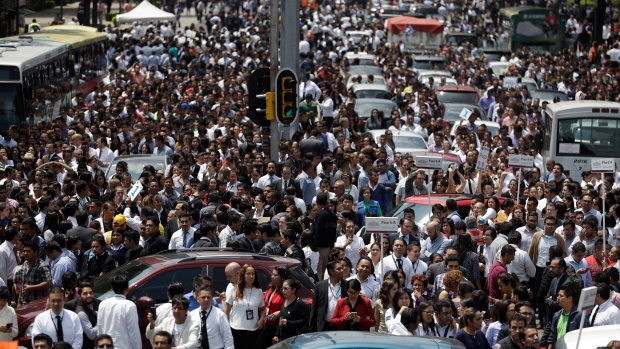 People evacuated from office buildings gather aftter Mexico City earthquake
