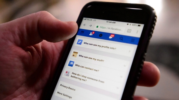 A cell phone user thumbs through the privacy settings on a Facebook account in Ottawa
